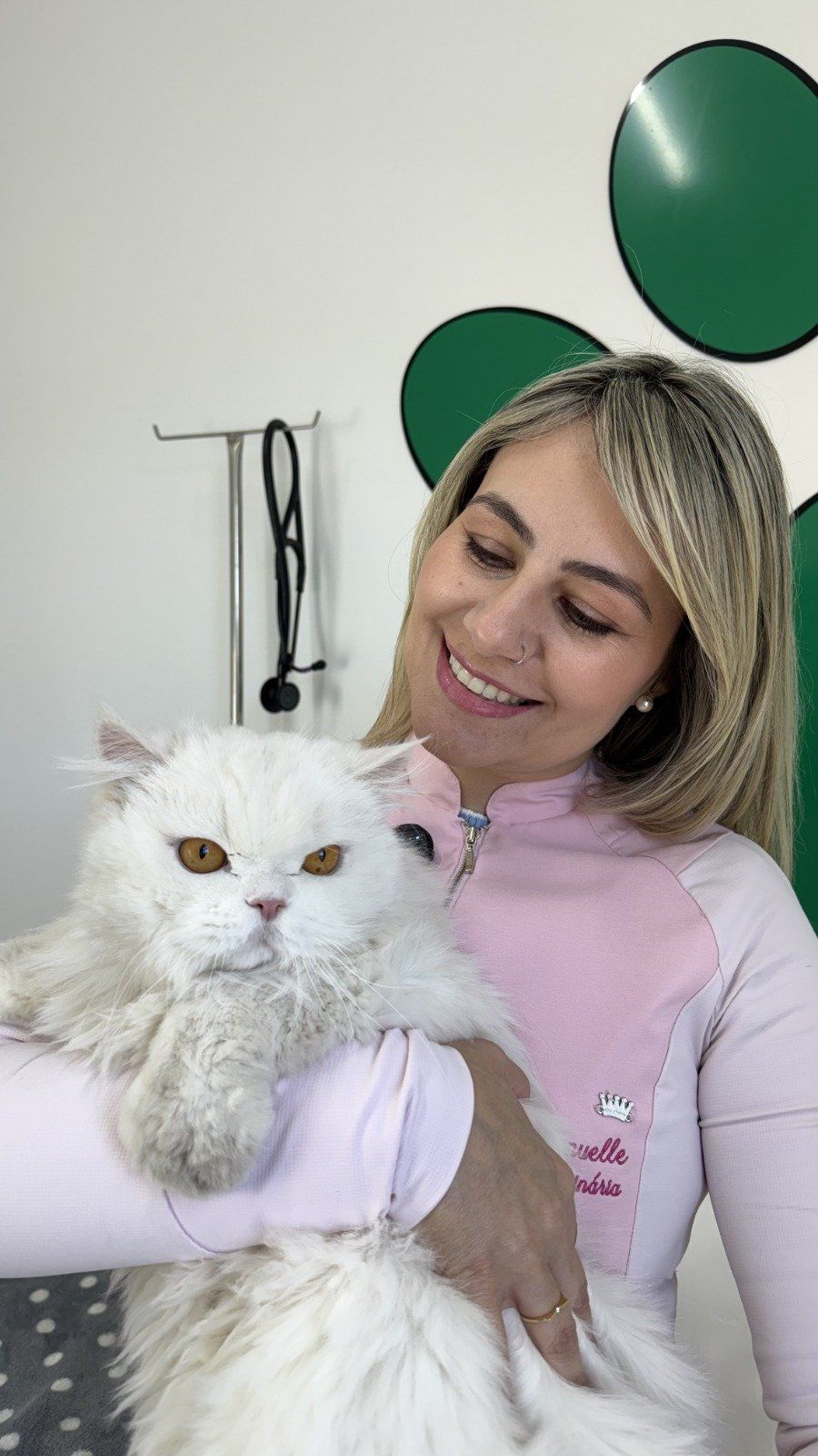 Médica veterinária do Le Petit abraçando um gato persa branco